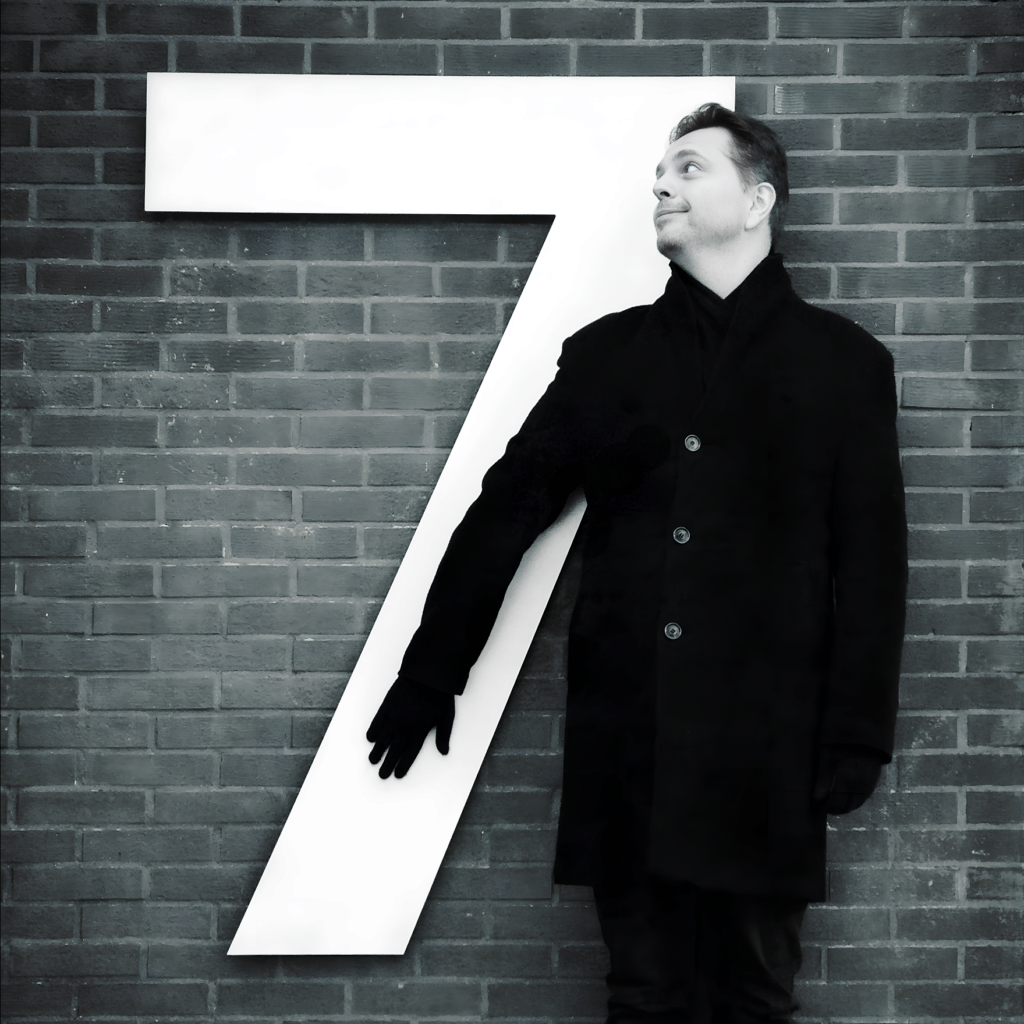 Photo of Metin Seven, standing in front of a large number 7